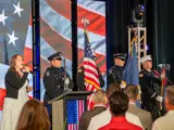 Honor Guard presents American flag while national anthem is sung.
